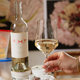 Person holding a glass of AXR Sauvignon Blanc